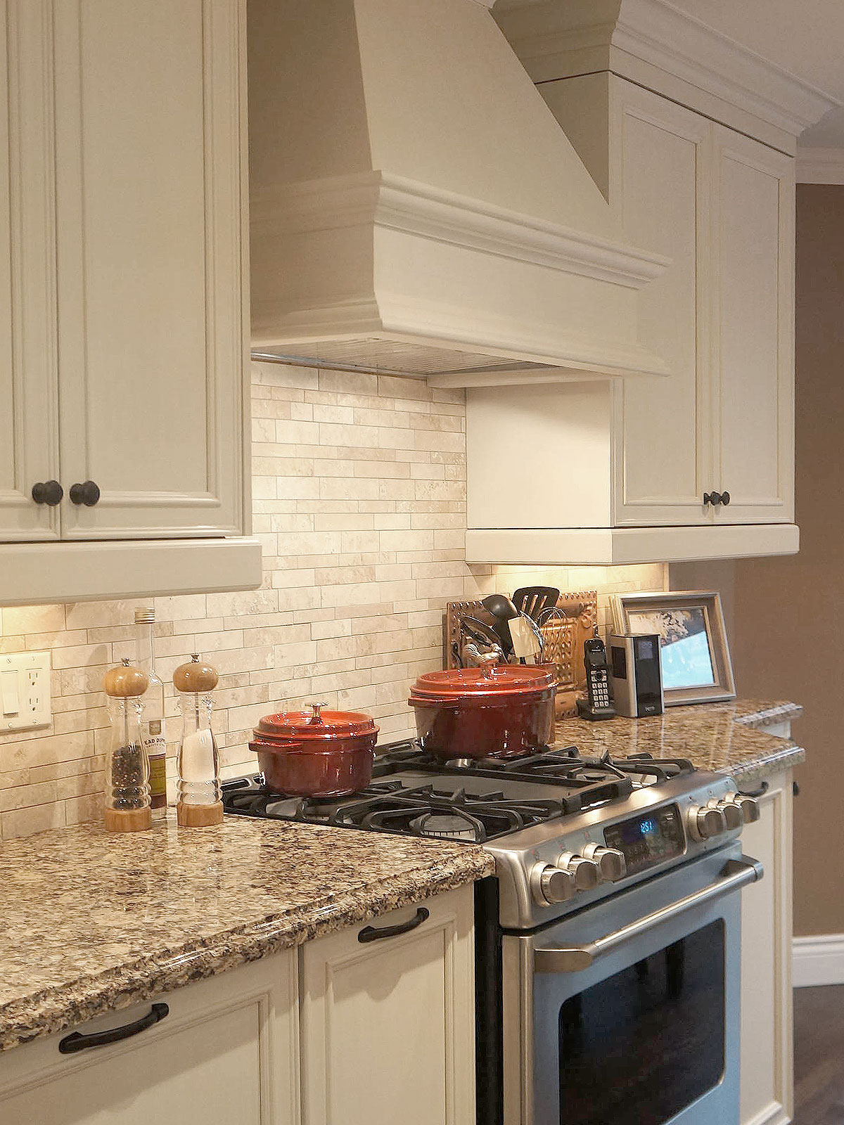 brown countertop beige cabinets travertine backsplash tile